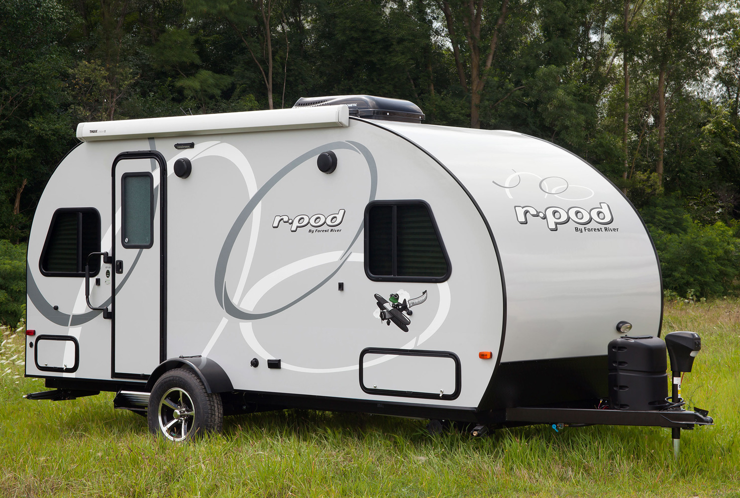 r-pod parked in a grassy campsite in the forest