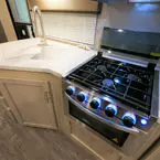 Sink Cover Shown Open, Three Burner Cook Top with Glass Cover Shown Open.
 May Show Optional Features. Features and Options Subject to Change Without Notice.