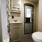 Mirrored Medicine Cabinet with Single Bowl Vanity Below. Entry Door and Foot Flush Toilet.
 May Show Optional Features. Features and Options Subject to Change Without Notice.