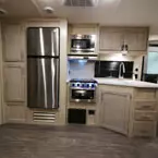 Kitchen Galley Area- Two Door Pantry, Stainless Steel Refrigerator, Microwave and Cabinets Mounted Overhead of Stove/Oven, Kitchen Sink with Sink Covers. Drawers Below.
 May Show Optional Features. Features and Options Subject to Change Without Notice.