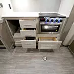 Four Cabinet Drawers, One Cabinet Door All Shown Open, Next to Stove/ Three Burner Cook Top.
 May Show Optional Features. Features and Options Subject to Change Without Notice.