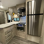 Kitchen view with storage cabinets, sink, stove, microwave, and refrigerator
 May Show Optional Features. Features and Options Subject to Change Without Notice.