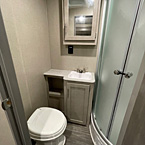 Bathroom with marine toilet with foot flush, sink with cabinet storage, mirrored medicine cabinet and shower
 May Show Optional Features. Features and Options Subject to Change Without Notice.