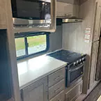 Closer view of kitchen with microwave oven and 3 burner SST range with flush glass top and drawer plus cabinet storage space May Show Optional Features. Features and Options Subject to Change Without Notice.