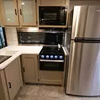 Kitchen with oversized refrigerator, spice rack, overhead microwave and cabinet, and a double basin sink. May Show Optional Features. Features and Options Subject to Change Without Notice.