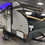 Front quarter view of Aurora 16BHX with door-side awning shown extended May Show Optional Features. Features and Options Subject to Change Without Notice.