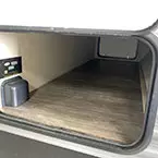 Close-up of pass thru storage with door-side panel door shown open May Show Optional Features. Features and Options Subject to Change Without Notice.