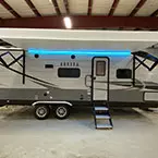 Door-side view of unit with awning and RGB light strip shown extended and on May Show Optional Features. Features and Options Subject to Change Without Notice.