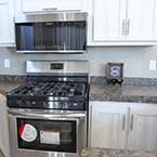 Kitchen galley with 3 burner range, overhead microwave and cabinetry May Show Optional Features. Features and Options Subject to Change Without Notice.